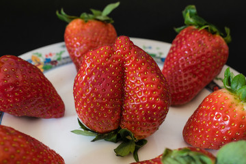 delicious strawberries on a plate with black background