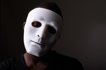 Portrait of young black African man in dark room wearing mask