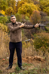 Young man with beard and mustache wearing glasses in brown jacket showing fingers