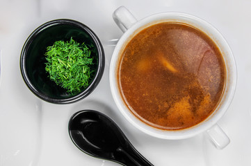 Delicious appetizing autumn soup with fresh vegetable in a bowl served on the table and black spoon. Closeup from above