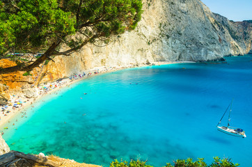 Fototapeta premium Porto Katsiki beach in Lefkada island, Greece. Beautiful view over the beach. The water is turquoise and there are tourists on the beach and a boat on the sea.