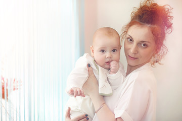 Baby in the arms of the girl. Mom holds her child in her arms. Happy mother with a little baby.