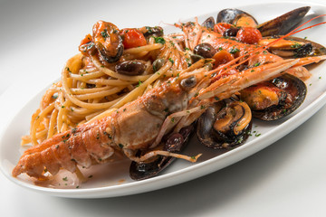 Plate of spaghetti with prawn mussels olives and tomatoes