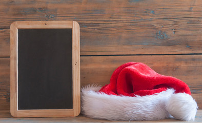 Obraz na płótnie Canvas Santa hat on wooden table with copy space