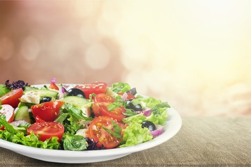 Greek salad with fresh vegetables on background