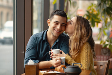 Young couple in love sitting in a cafe, drinking coffee