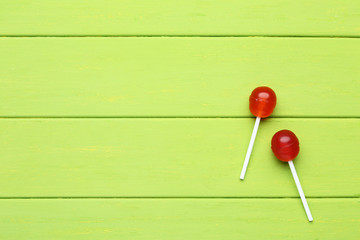 Sweet lollipops on green wooden table
