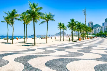 Fotobehang Rio de Janeiro Heldere ochtendweergave van het gebogen promenade-tegelpatroon met palmbomen op het strand van Copacabana met de skyline van Rio de Janeiro, Brazilië