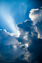Fototapeta na wymiar Heavenly light shining through billowing clouds in a stormy sky