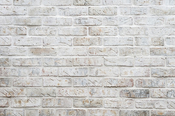 White painted brick wall full frame background with gritty textured imperfections