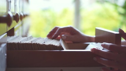 Hands of woman checking cards at library
