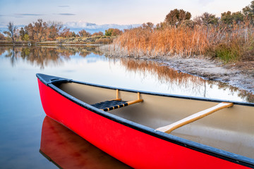 red canoe on a lake shore