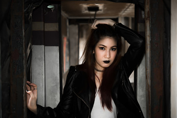 Portrait of asian with black leather dress punk style on train,Thailand people take a picture