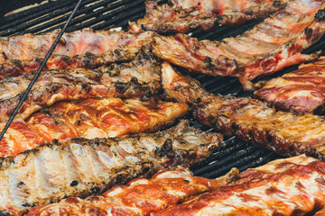 Grilled ribs. Street food. Fried meat on grill. Golden roasting