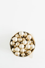 Box with golden Christmas decoration balls on white background. Flat lay, top view blog hero header.