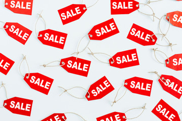 Black Friday sales discount composition. Red tags with word SALE on white background. Flatlay, top view.