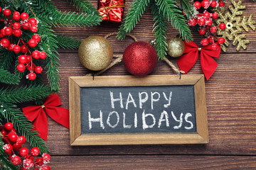 Inscription Happy Holiday on wooden frame with fir-tree branches and baubles