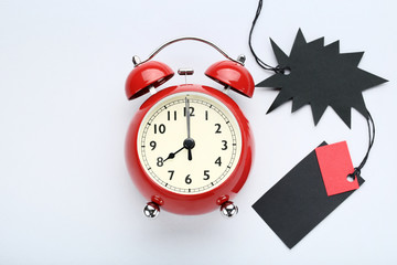 Black sale tags with alarm clock on grey background