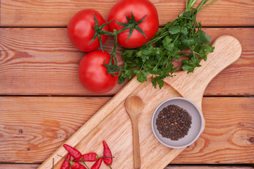 tomatoes, peppers, fresh greens, garlic on a wooden plate. country style