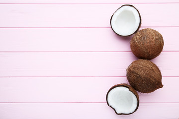 Ripe coconuts on pink wooden table