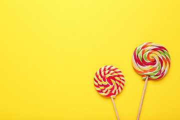Colorful lollipops on yellow background