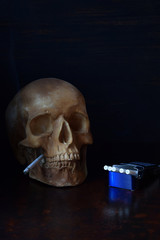 Human skull with a cigarette in teeth on dark background. Stop smoking concept. Nicotine addiction and bad habits