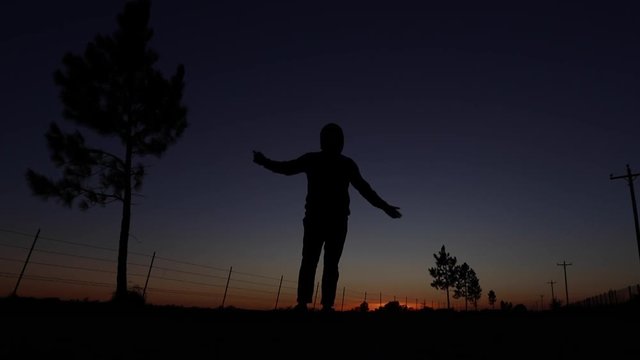 Guy dancing with sunset background.