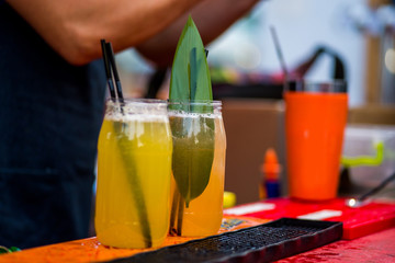 barkeeper preparing a cocktail in a plastic glass outdoors. catering