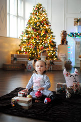 Ребенок ждет чуда в Новый год. С новым годом! Счастливого Рождества! Новогодняя елка с рождественскими игрушками. Девочка с подарками.

