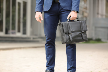 Businessman with black briefcase in hand outdoors