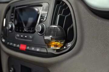 Stylish air freshener hanging near car ventilation