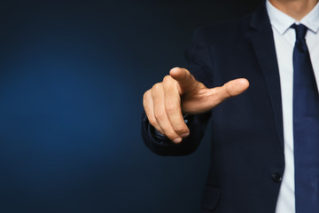Businessman pointing on color background, closeup view of hand with space for text