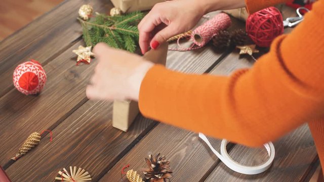 Christmas presents wrapped in eco paper with homemade decoration on wooden background with decor elements and units