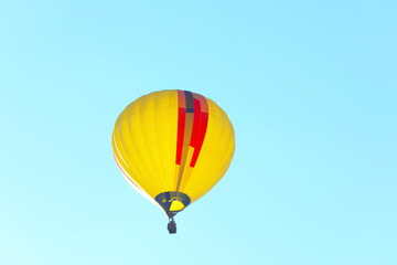 Colorful hot air balloon flying in blue sky. Space for text