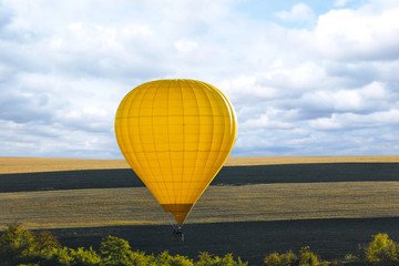 Fototapeta premium Colorful hot air balloon flying over field