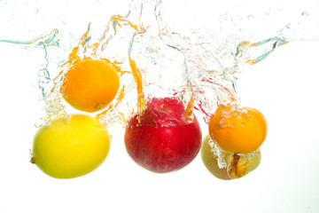 Fototapeta na wymiar Varius fruits apple pear lemon and clementine splash in water in white