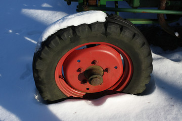 Rad eines alten Traktors steckt im Schnee fest