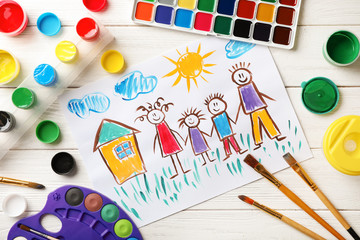 Flat lay composition with child's painting of family on table