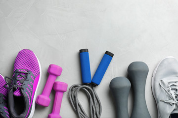 Flat lay composition with jump rope, gym equipment and space for text on grey background