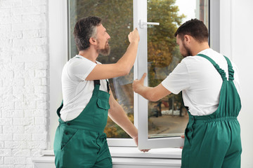 Construction workers installing new window in house