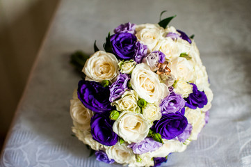 Violet and white flowers bouquet with golden rings on the table