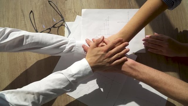 Close-up of the hands of office staff folding each other