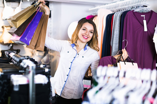 female shopper examining long sleeve shirts in underwear shop