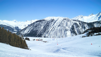 Fototapeta na wymiar Panoramic winter landscape of skiing, snowboarding slopes pine forest, chalet restaurant, chair lift in 3 Valleys resort of Courchevel, Alps, France .