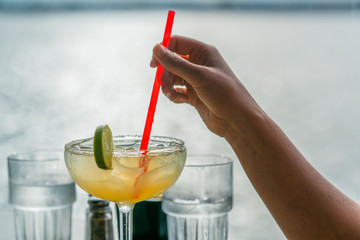 Close up girl hands with mojito and lime and red straw