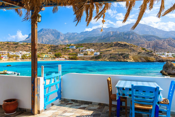 Terrace with table in traditional Greek tavern in Lefkos port on Karpathos island, Greece
