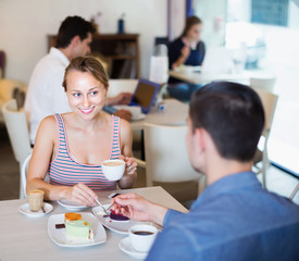 Obraz na płótnie Canvas Woman with husband enjoying coffee with dessert
