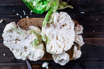 Cauliflower on the wooden board with knife. Still life of food. Process of cooking. Vegetarian concept. Cooking concept. Vegan food. Cabbage. Organic food.