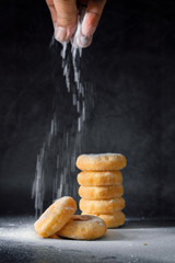 Donut on a dark background. Sprinkle powder on top.