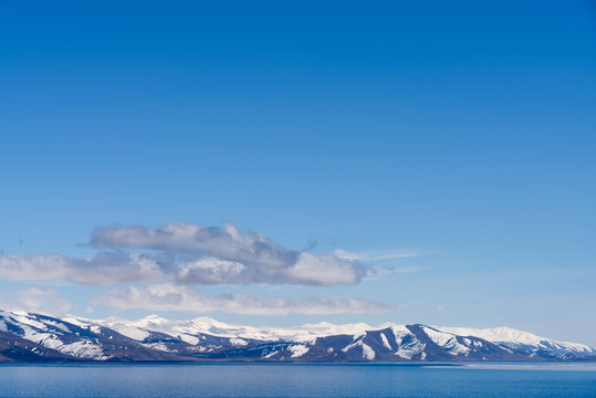 Alpine lake Sevan covered partly by ice on sunny April afternoon